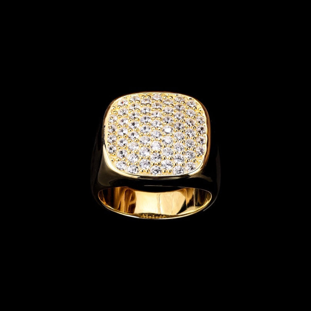 Gold ring with diamond-studded face on a black background